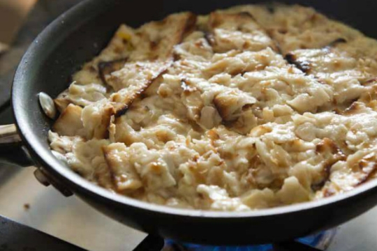 Matzah brei cooking in a pan on the stove